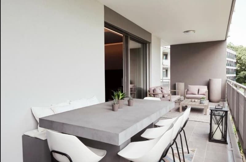 Long table, cushioned seating, potted plants, lanterns, modern decor, sliding glass doors, outdoor chairs, open layout