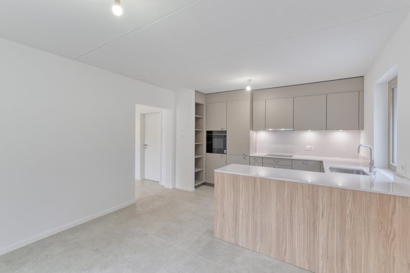 modern kitchen with white walls, wooden countertops, built-in oven, dishwasher, and washing machine