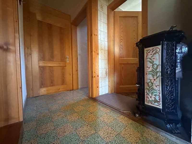 Checkered flooring, wooden doors, white tiles near the door, fireplace