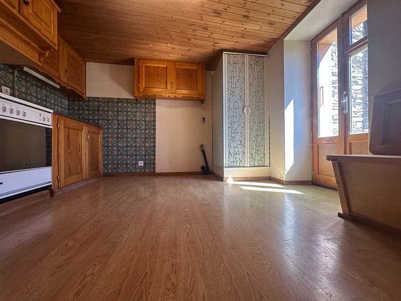 empty room, wooden floor, wooden cabinets, tiled wall, white oven, glass door, wooden ceiling