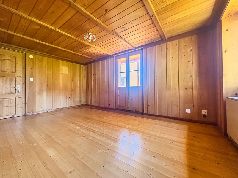 wooden floor, wooden walls, open door leading to another room, sunlight coming through the window