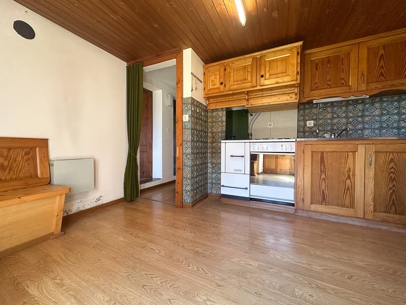 empty kitchen with wooden flooring, white walls, tiled walls, wooden cabinets, oven and sink