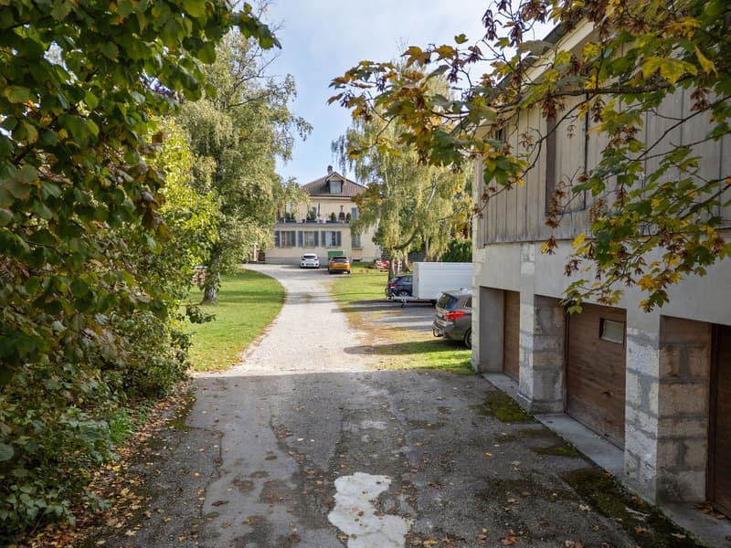 Driveway with cars parked, garage, house in background
