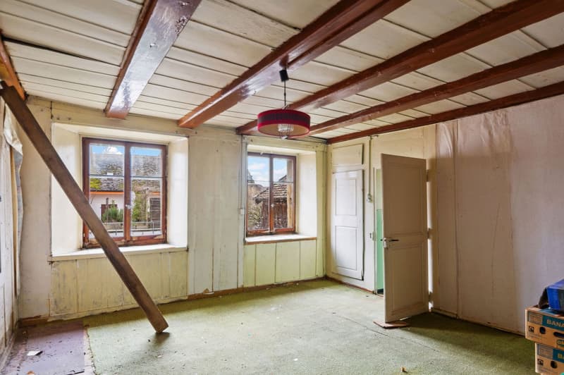 empty room, wooden beams, two windows, open door, green carpet