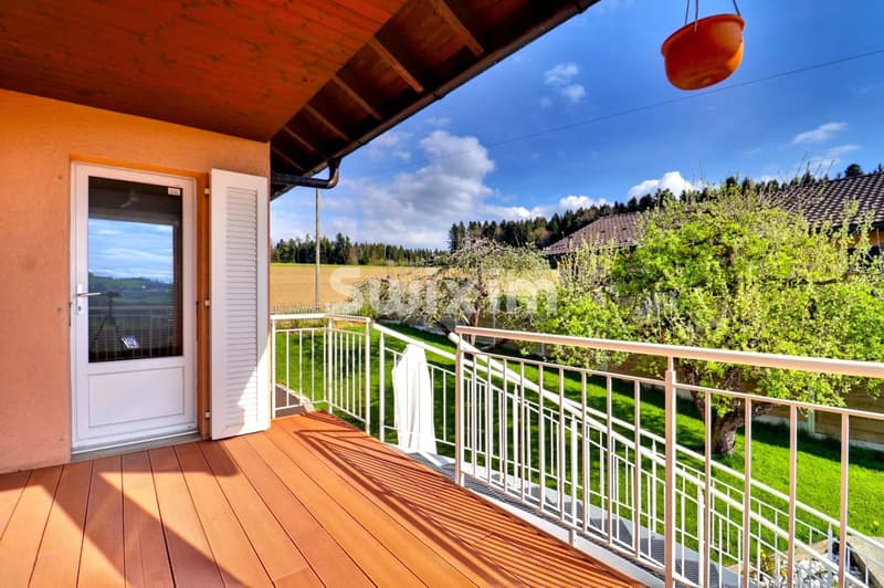 Balcon en bois offrant une vue panoramique sur la nature environnante.