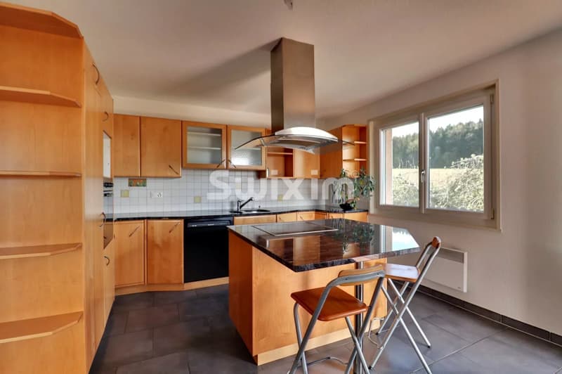 Cuisine lumineuse avec vue sur l'extérieur.