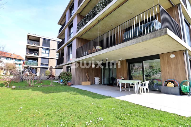 Appartement moderne avec terrasse et espace vert privé.