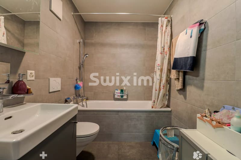 Salle de bain lumineuse avec baignoire, idéale pour la détente.