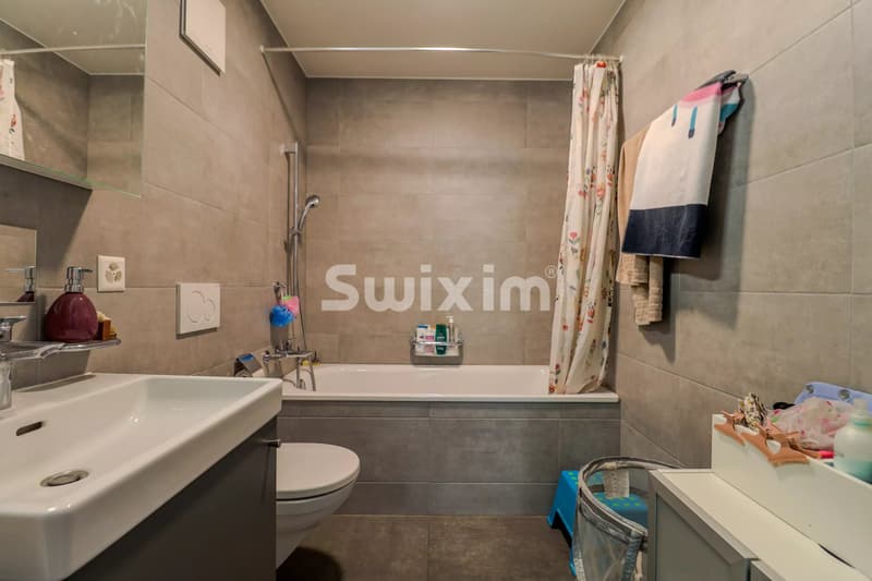 Salle de bain lumineuse avec baignoire, idéale pour la détente.
