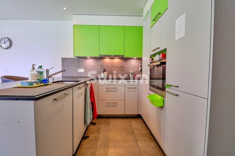 Cuisine moderne avec rangements spacieux et appareils intégrés.