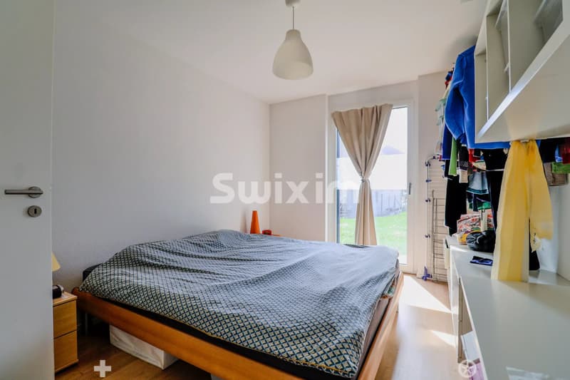 Chambre lumineuse avec vue sur l'extérieur et espace de rangement intégré.