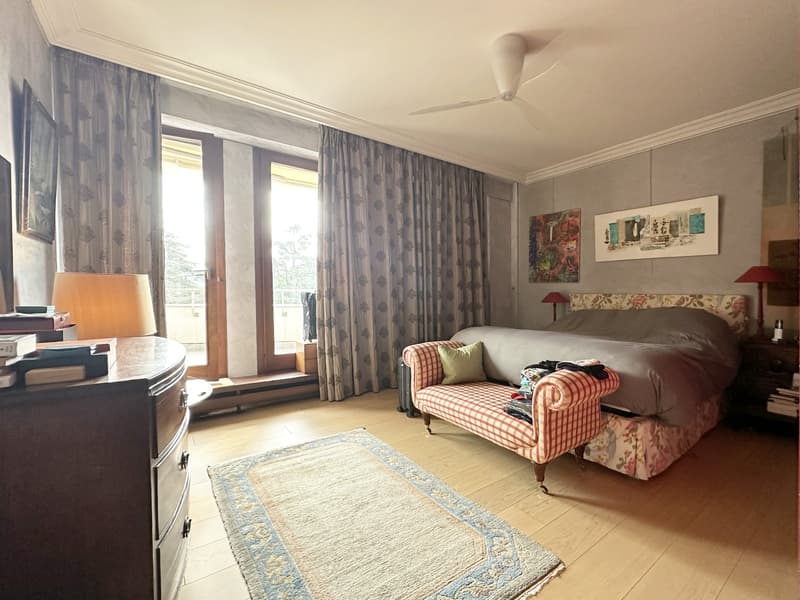 bedroom with hardwood floor, bed, rug, nightstand, couch, lamp, window, balcony