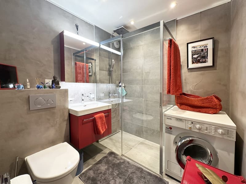 tiled floor, glass enclosed shower, glass shower door, red towels, washing machine