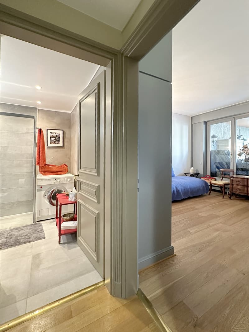 room with a laundry machine, a chair, and a wooden chest