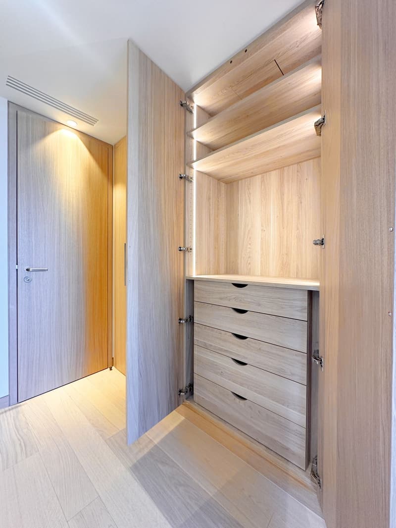 walk-in closet with wooden shelves, drawers, and built-in lighting