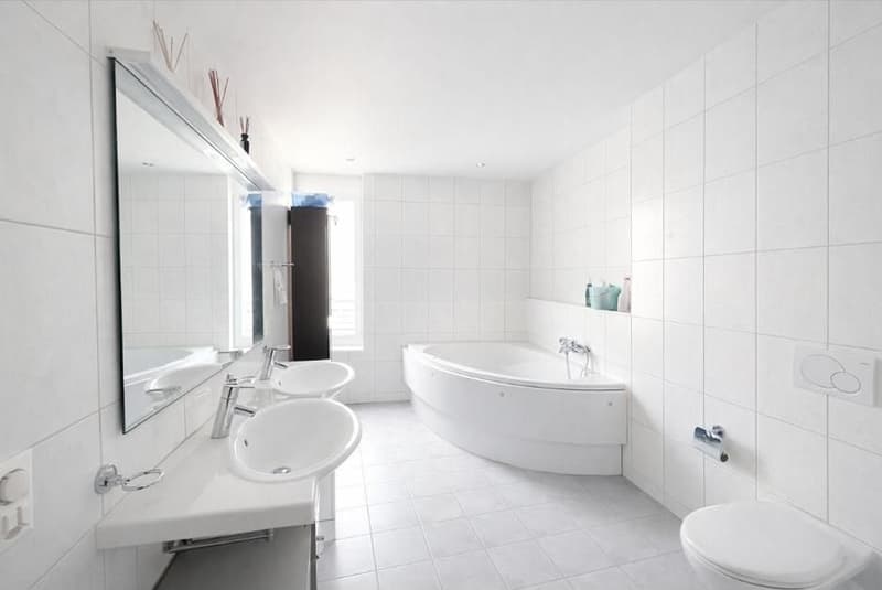 Bathroom with a bathtub, sink, and a mirror