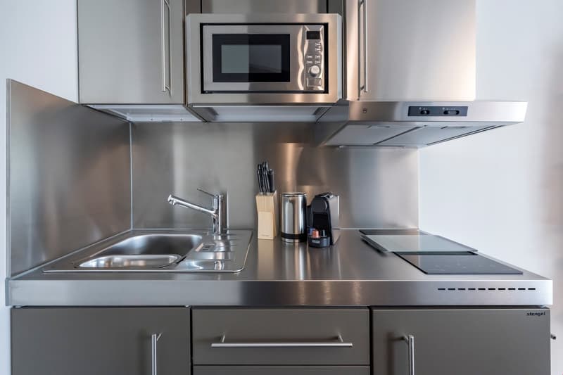 Stainless steel kitchen with built-in microwave, dishwasher, sink, and countertop space
