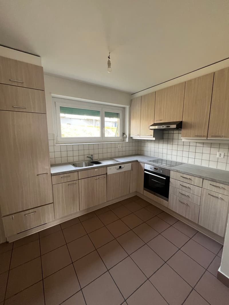kitchen with tiled floor, kitchen island with sink and dishwasher, oven, cabinets, wooden floor