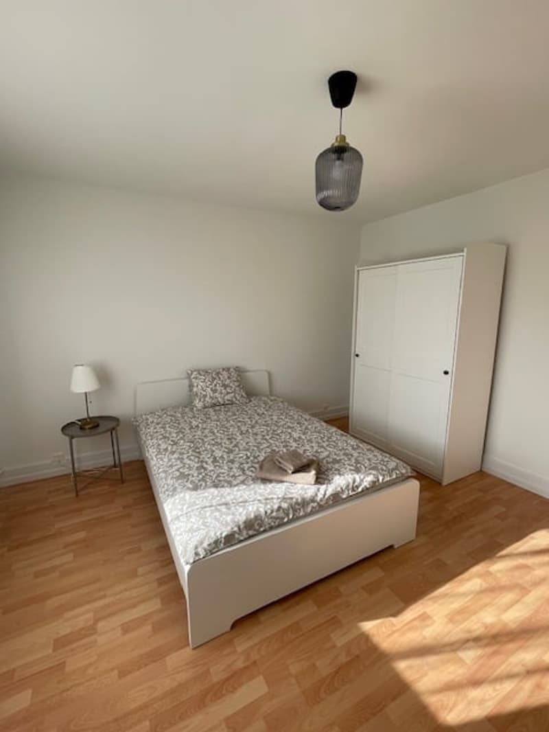 single bed, wardrobe, lamp on nightstand, wooden floor