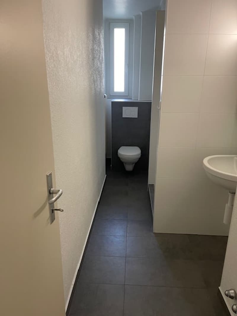 Small room with toilet, sink, and window