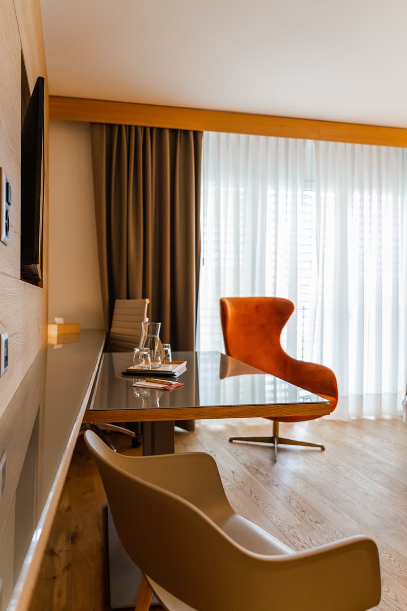 modern office setup with desk, chairs, and a TV mounted on the wall