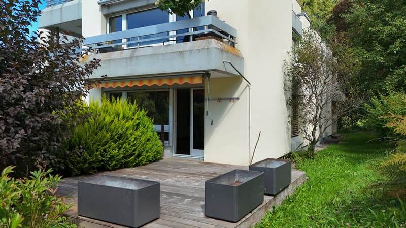 white house, wooden deck, balcony, metal planters, shrubs, trees