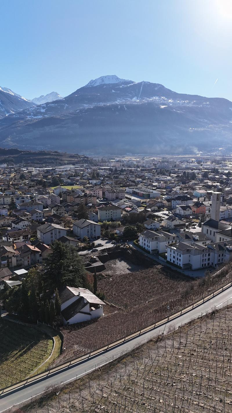 aerial view of town with mountain background, many buildings, road, and farmland