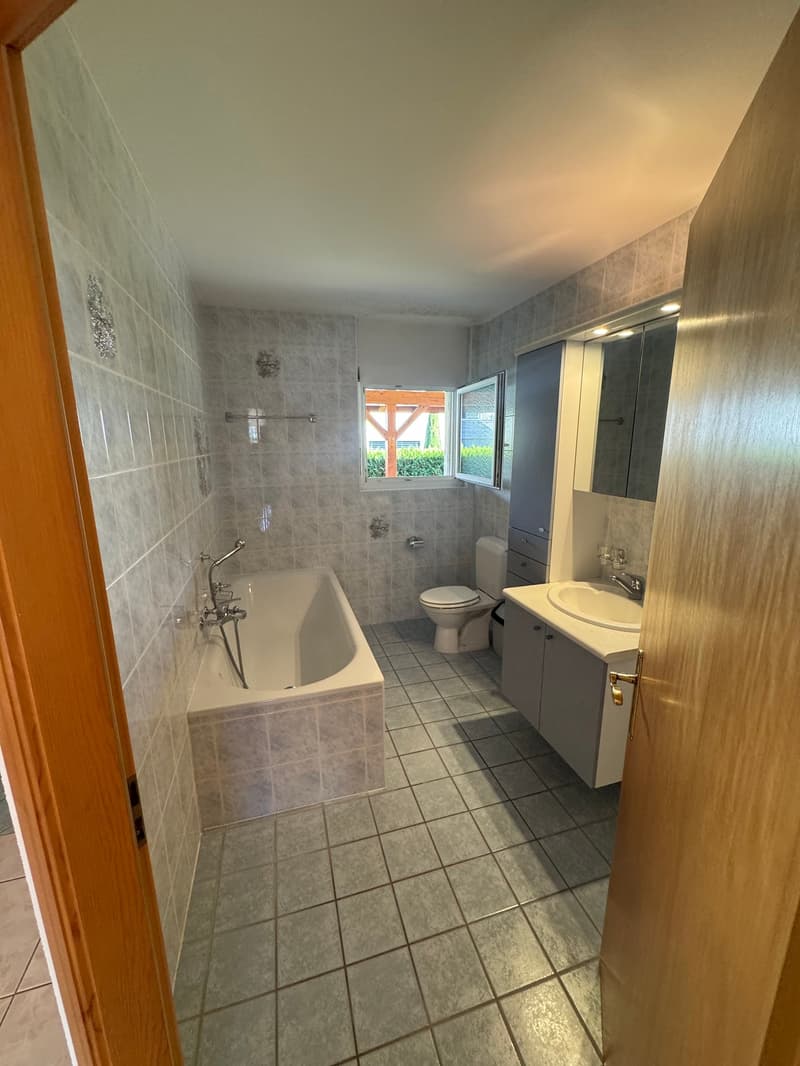 Bathroom with bathtub, toilet, sink, and mirror