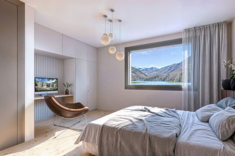 Wood floor, bed with two pillows, chair, computer, window with curtain