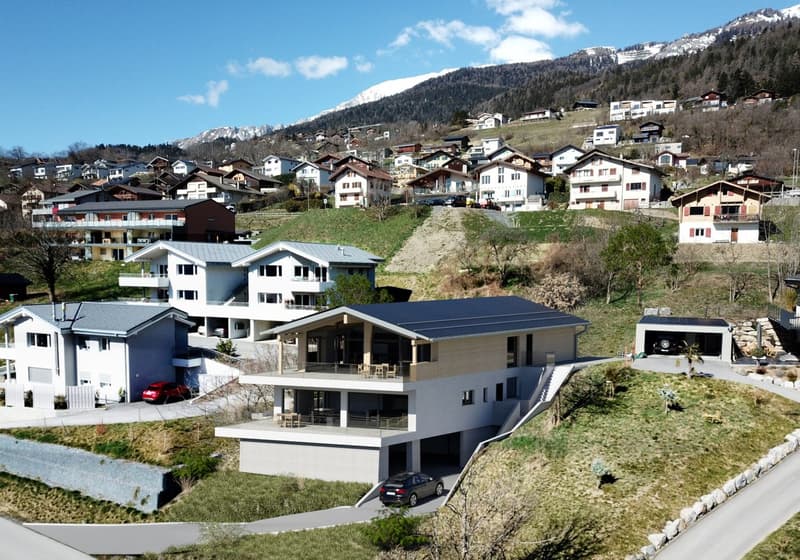 Modern house with multiple levels, large windows, balconies, and a garage