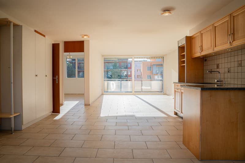 Open floor plan, tile flooring, modern cabinets, skylights, glass doors to balcony