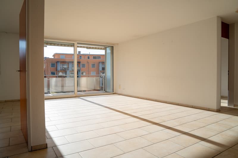 empty room with tile flooring, sliding glass door to balcony, white walls