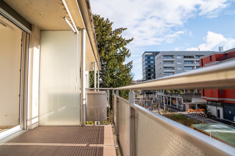 Empty balcony with metal railing, open glass doors, tiled floor, side wall