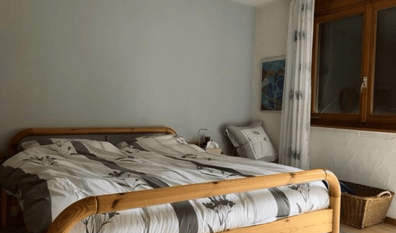 bedroom with bed, nightstand, lamp, basket, picture frame, curtains