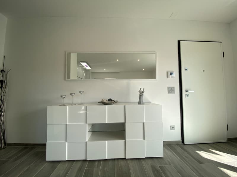 white wall, white cabinet, mirror, wine glasses, sculpture, door