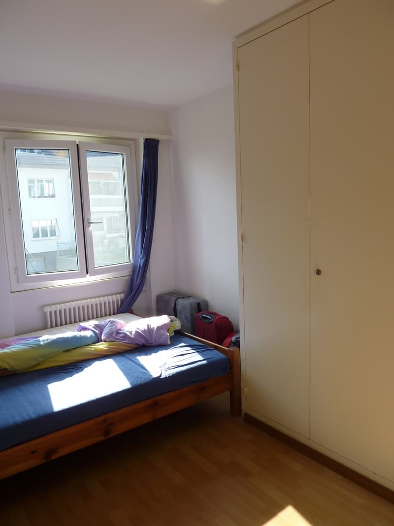 bedroom with bed, window, wardrobe, luggage, radiator