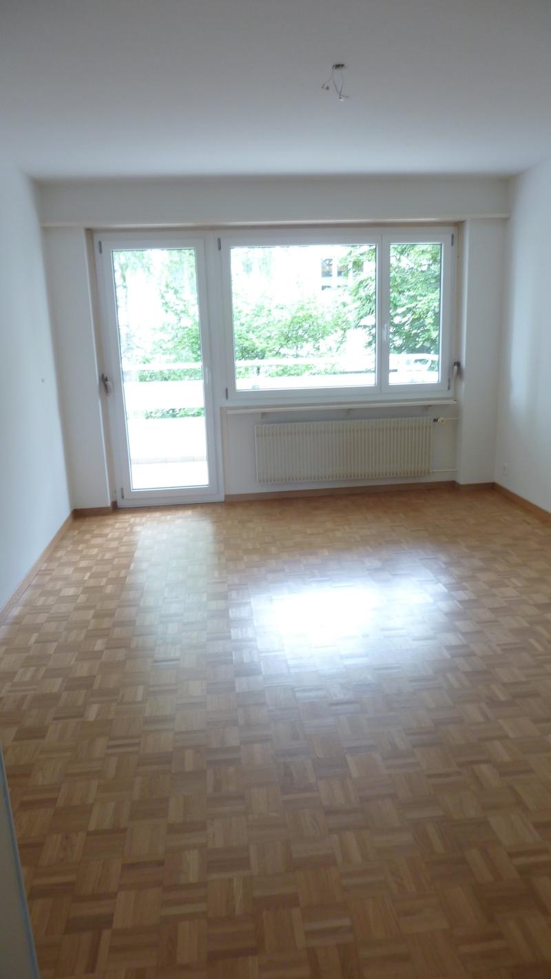 empty room, wooden floor, sliding glass door, windows, balcony, radiator