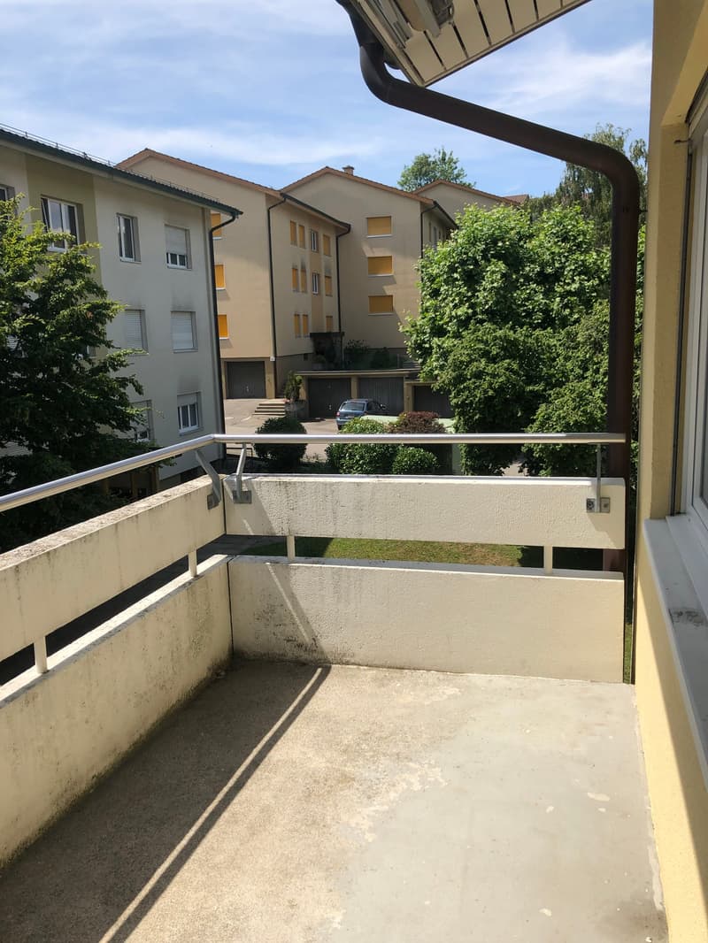 empty balcony with metal railing, concrete floor, shadow on the floor