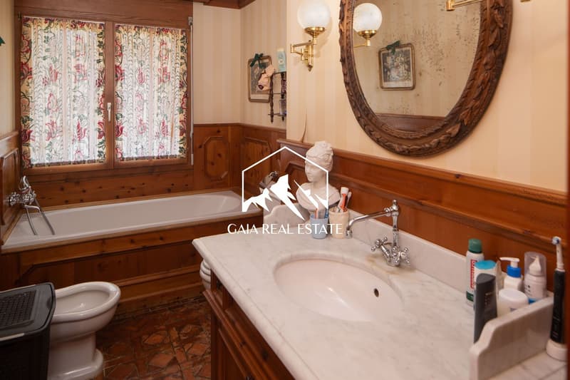Bathtub, marble counter, mirror, toilet, sink, wooden walls, window