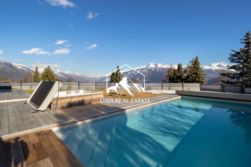 Outdoor swimming pool with wooden deck, hot tub, and a view of the mountains