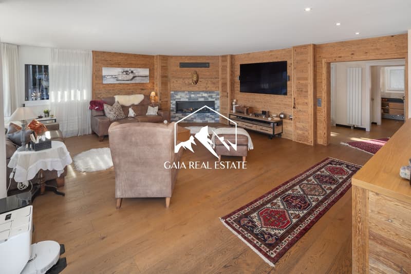 wooden walls, fireplace, flat screen TV, sofa, armchair, coffee table, rug