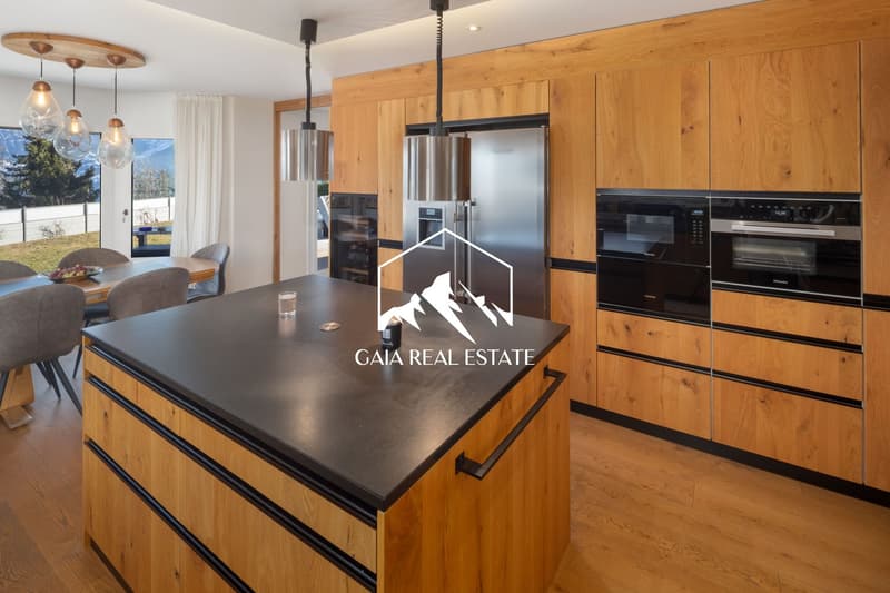 modern kitchen, wooden cabinets, black granite countertop, stainless steel appliances, pendant lights, dining table, chairs