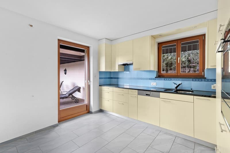 Kitchen with tiles, white walls, wooden floor, dishwasher, washing machine