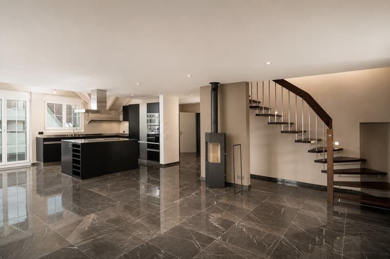 Blick ins unmöblierte Wohnzimmer mit Kücheninsel