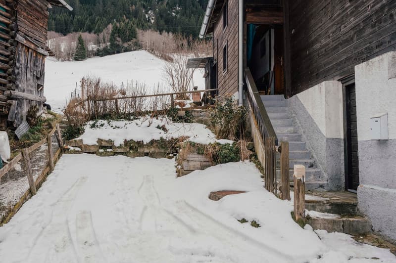 wooden building, snowy walkway, stairs to entrance, fenced garden