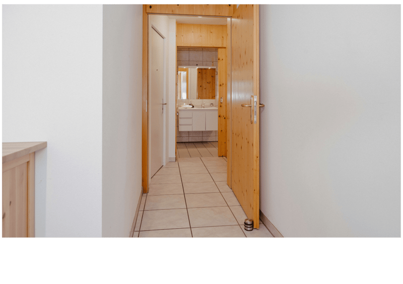 tiled floor, wooden door, white walls, bathroom with sink and mirror