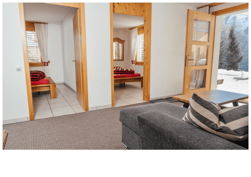 living room with sofa, coffee table, carpet, wooden doors, windows, view of mountains
