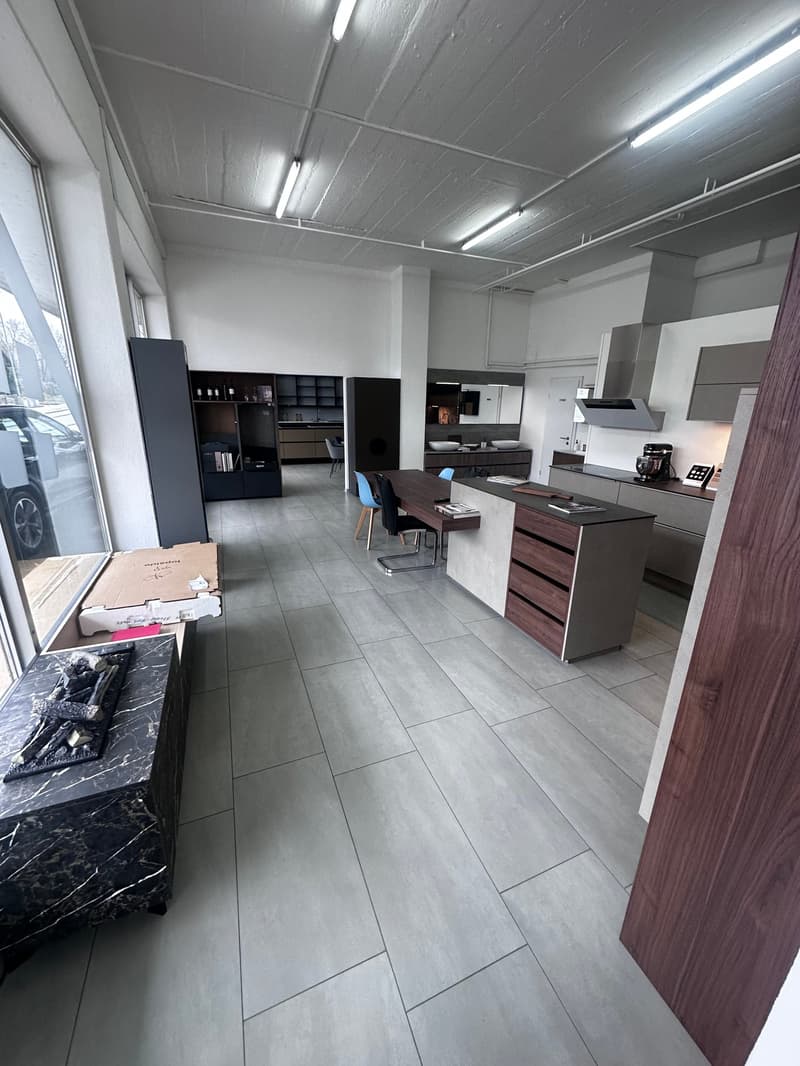 Large modern kitchen, grey tiled floor, white ceiling, white cabinets, marble countertop, dining table, chairs