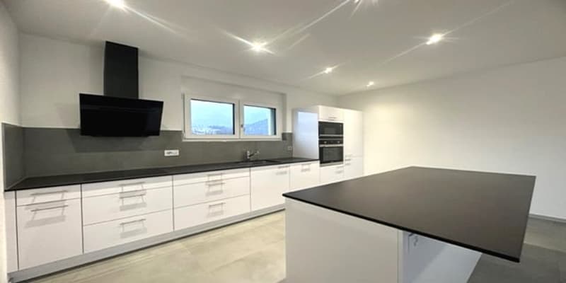 empty kitchen with white cabinets, black counter, black hood, white fridge, black top