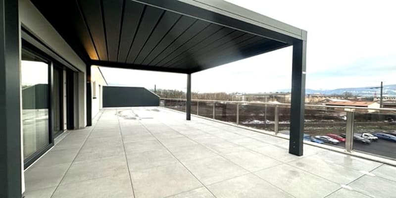 covered terrace with a tiled floor and railings, overlooking a parking lot